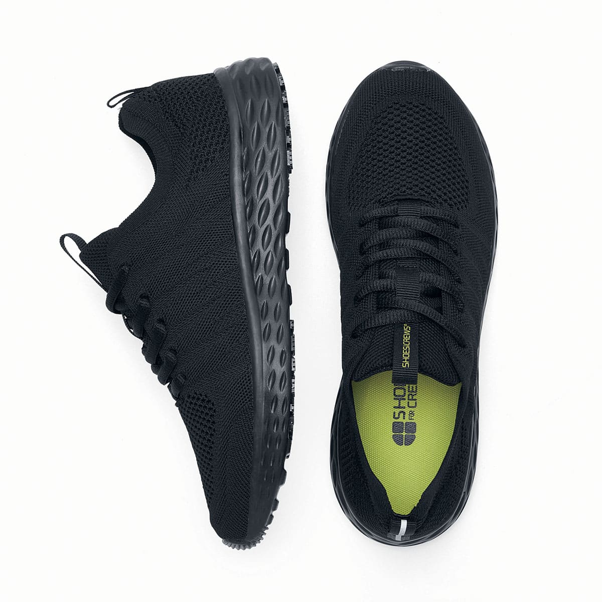 The Everlight™ Everlight Eco Women's Black from Shoes For Crews are lightweight and breathable slip-resistant trainers made from recycled materials, viewed from the side and bottom at a vertical angle.