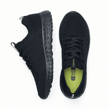The Everlight™ Everlight Eco Women's Black from Shoes For Crews are lightweight and breathable slip-resistant trainers made from recycled materials, viewed from the side and bottom at a vertical angle.